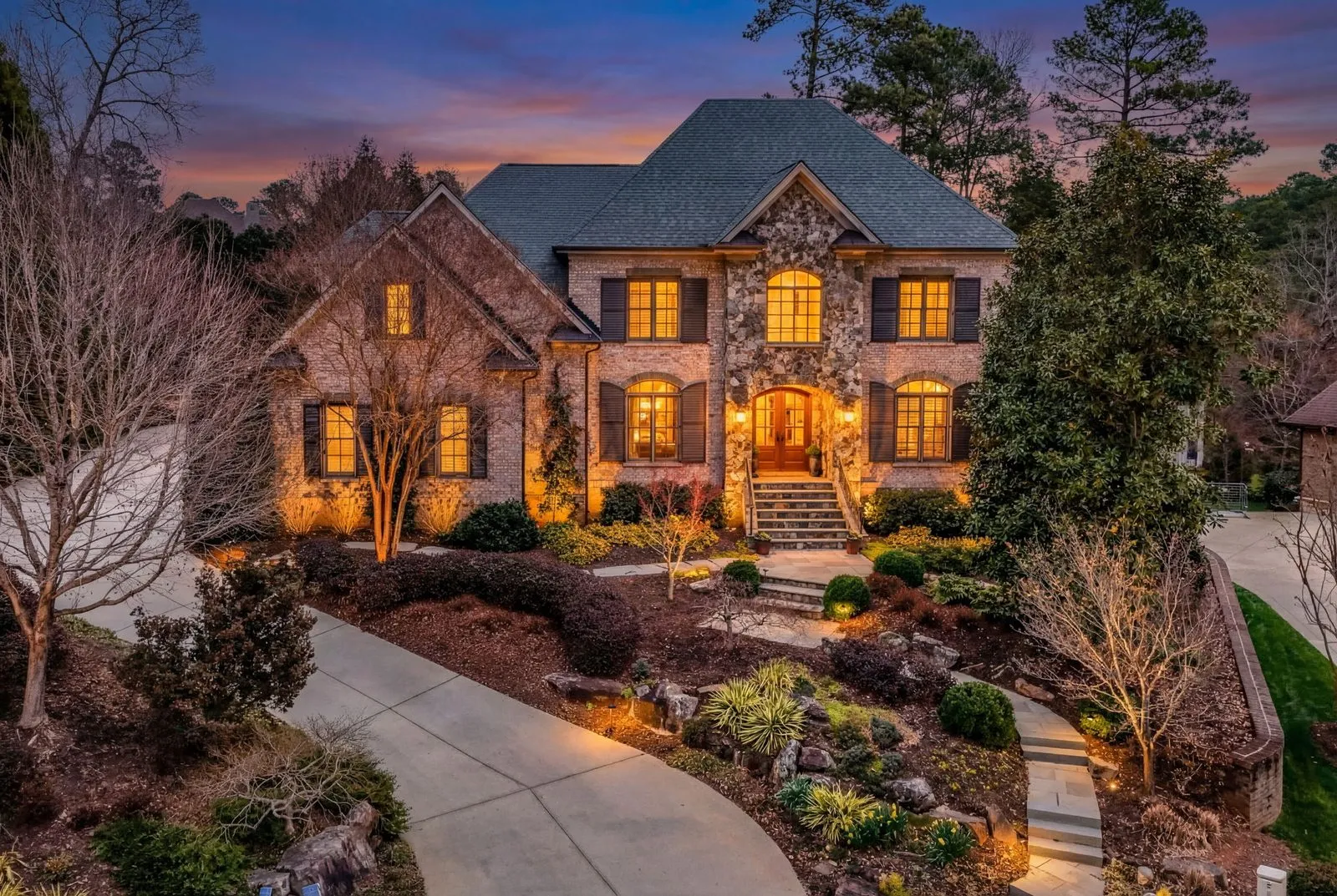 Aerial of 3604 Nightfall Ct showing the saltwater pool, outdoor kitchen, and wooded Umstead Park backdrop